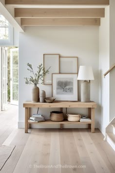 a wooden table sitting in the middle of a living room next to a stair case