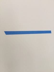 a piece of paper with blue tape on it