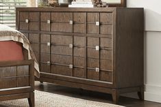 a wooden dresser sitting next to a bed in a bedroom