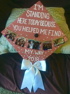 a graduation cap that has been decorated with pictures and words on it, sitting on top of a pillow