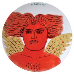 a plate with an image of a woman's face and wings painted on it