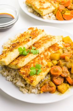 two white plates topped with fish and rice