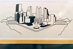 a drawing of a city is shown on the side of a bus window, and it appears to be in black and white