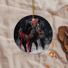 a round ornament with a black horse wearing a wreath on it's head