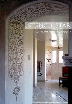 an archway leading into a bathroom with tile flooring and wall art on the walls