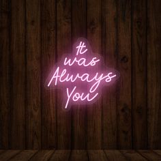 a neon sign that says it was always you on a wooden background with planks