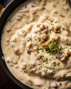 a skillet filled with mashed potatoes covered in gravy and garnished with parsley