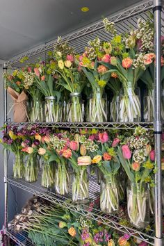 many vases filled with flowers sitting on shelves