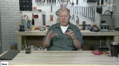 a man sitting in front of a table with tools on it