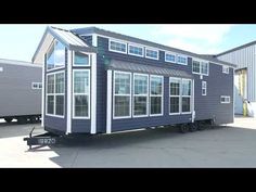 a blue and white tiny house sitting on the back of a truck