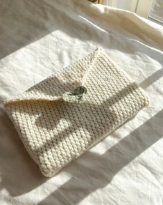 a white crocheted case sitting on top of a bed