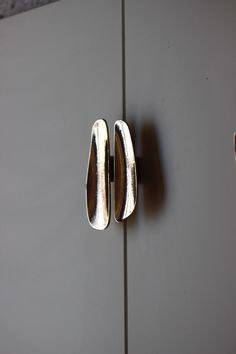 two silver door handles on a gray cabinet