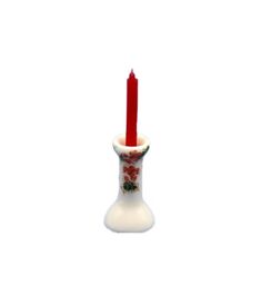 a red candle is in a white vase