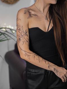 a woman with long hair and tattoos on her arm