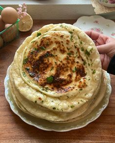 a stack of flatbreads sitting on top of a plate next to an egg