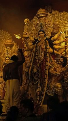 an idol is being displayed in front of a group of people at the temple,