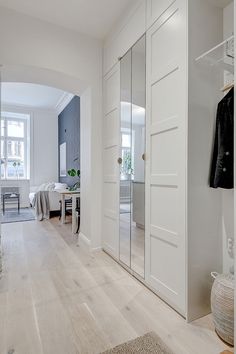 a hallway with white walls and wooden floors