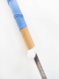 a pencil is wrapped in blue paper and has a ruler on the end of it