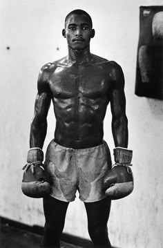 a man with boxing gloves standing in front of a wall