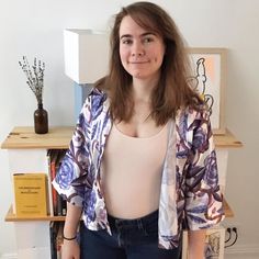 a woman standing in front of a book shelf