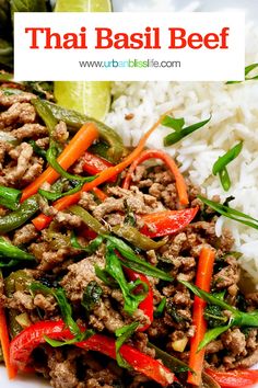 thai basil beef with rice and vegetables on a white plate in front of lime wedges