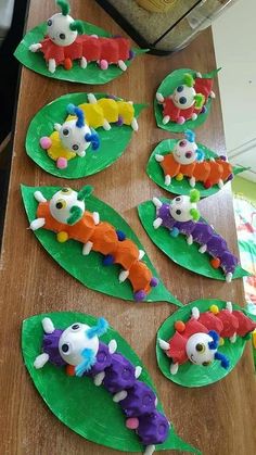 paper plate crafts that look like caterpillars with faces on them sitting on a table