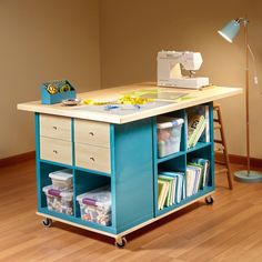 a sewing machine sitting on top of a wooden table next to a lamp and bookshelf