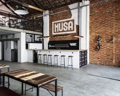 the inside of a building with tables and stools