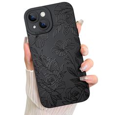 a woman holding up her phone case with flowers on the front and back cover in black