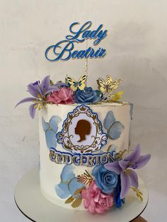 a birthday cake decorated with blue and pink flowers