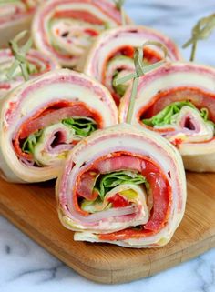 ham and lettuce wrapped in bacon on a cutting board