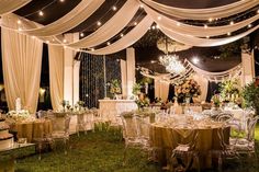 an outdoor wedding reception with clear chairs and white draping draped over the tables