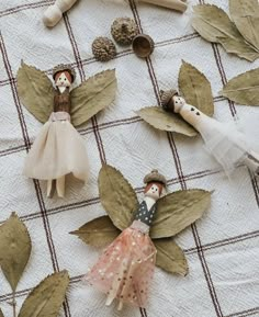 several wooden dolls are placed on a table with leaves