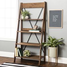 a book shelf with books and plants on it next to a potted houseplant