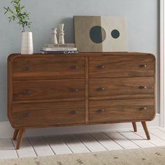 a wooden dresser sitting next to a blue wall