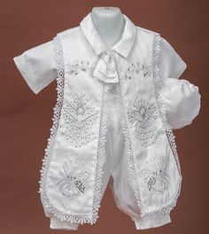 a white baby's christ gown and hat on display