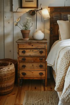 a bed room with a neatly made bed next to a night stand and a basket