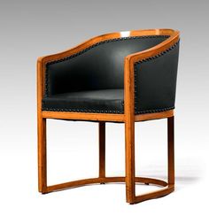 a wooden chair with black leather upholstered on the back and armrests