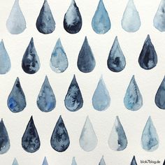 watercolor drops on white paper with blue and black ink in the middle, set against a white background