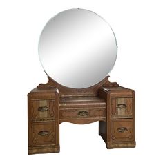 an antique vanity with a round mirror on it's top and two drawers underneath