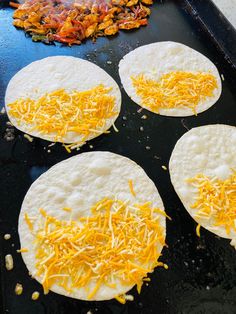 four tortillas with cheese are on a pan