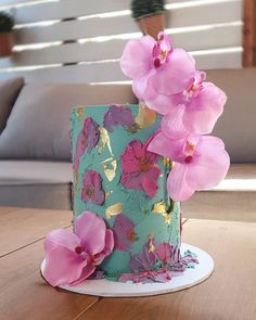 a blue cake with pink flowers on top