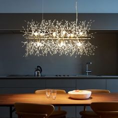 a dining room table with chairs and a chandelier hanging from it's ceiling