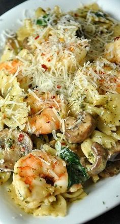 a white plate topped with pasta and shrimp