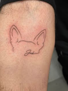 a man with a tattoo on his leg that has a dog's face drawn on it