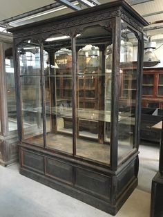 an antique china cabinet with glass doors and shelves