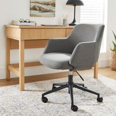 a gray office chair sitting on top of a rug in front of a wooden desk