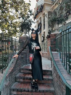 a woman standing on some stairs with her arms out in the air and wearing sunglasses