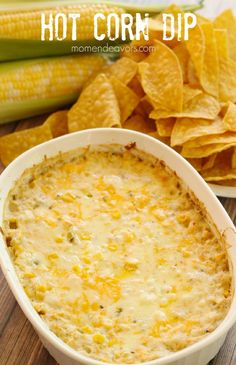 corn and cheese dip in a white bowl with chips on the side next to it