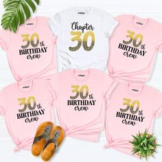 pink and gold birthday shirts with the number 30 printed on them, next to a pair of orange slippers